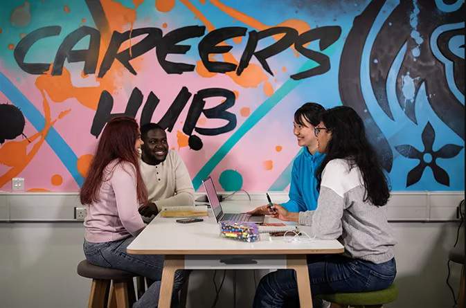 Four students at a table inside the Careers Hub