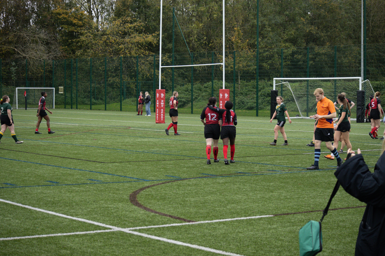 Rugby players walking back onto a field during a game.