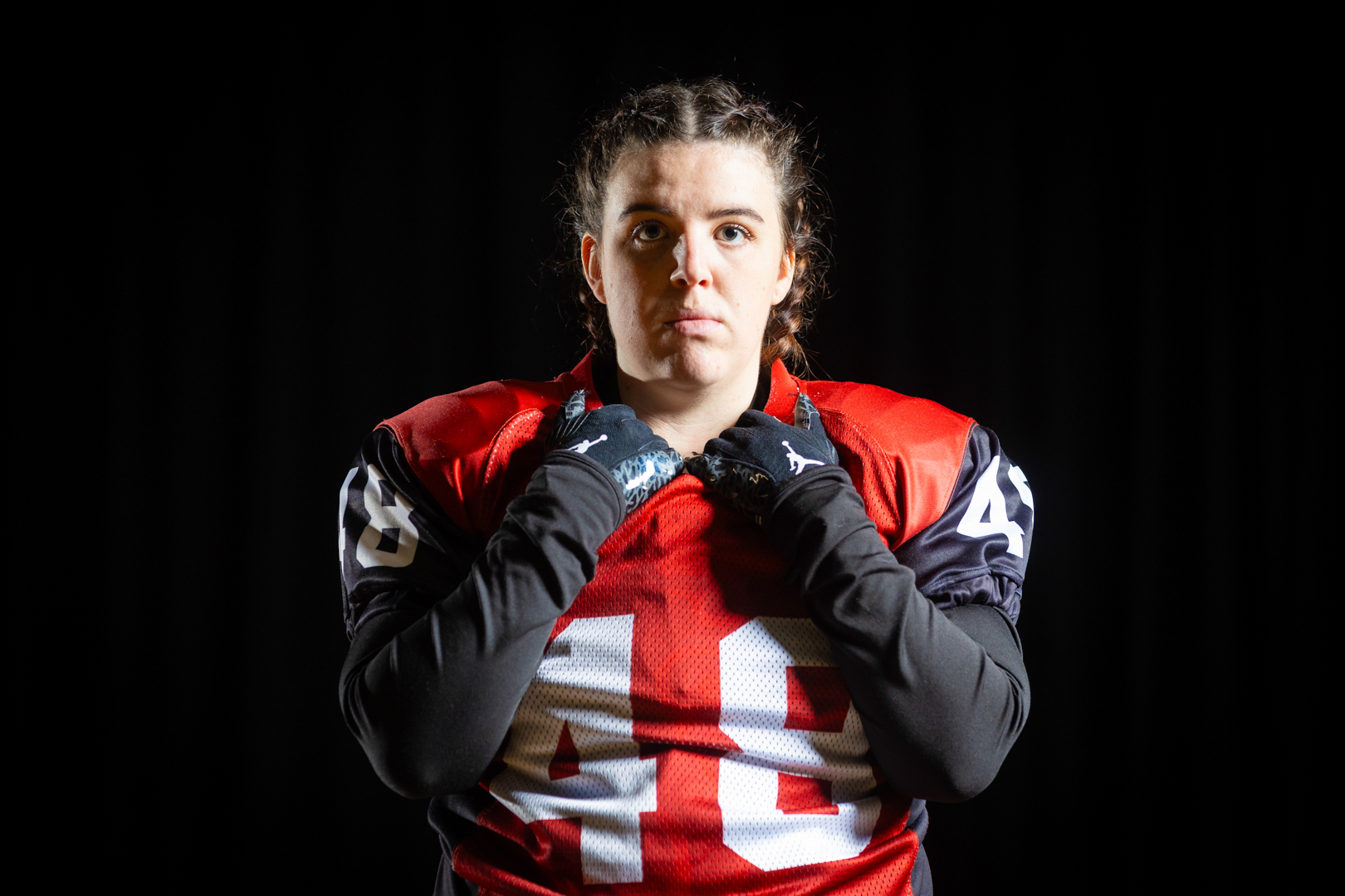 American Football player in a red jersey with number 48 poses against a dark background.