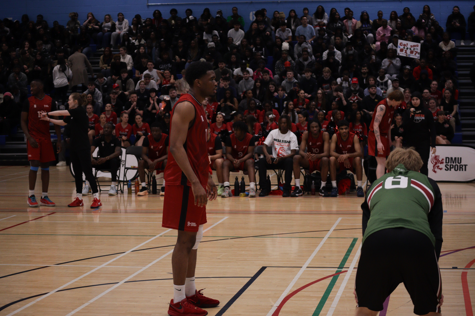 Basketball players on a court during a game, with one player preparing to take a free throw as others watch.