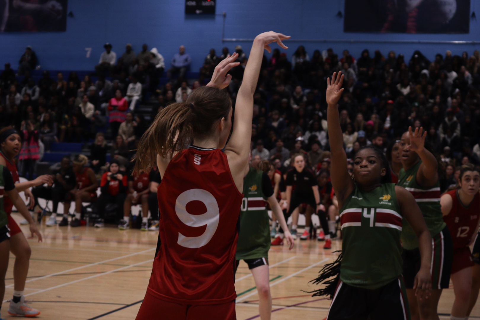 Basketball player in a red kit taking a shot.