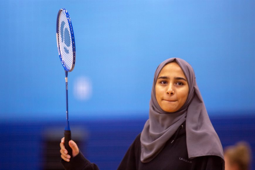 student holding a badminton racquet