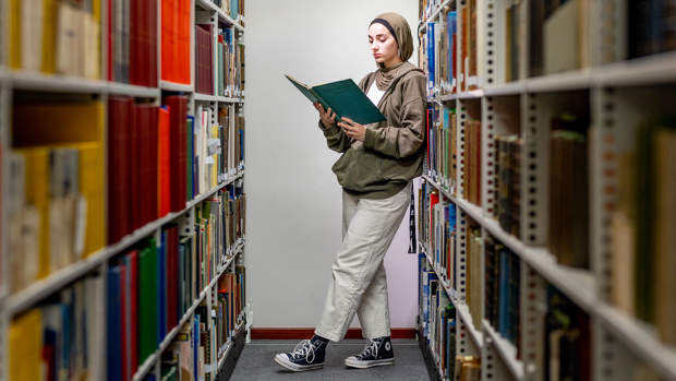 Student reading book in library