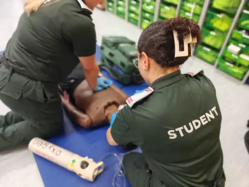 Two students practising advanced life support in the clinical skills lab on campus with an advanced manikin