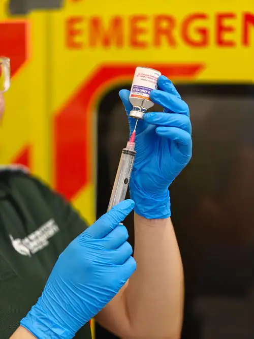 Student drawing up simulated drug from vial into syringe