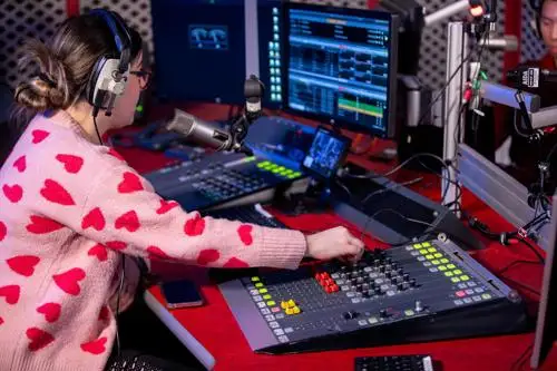 A student using the broadcast desk in the radio studio.