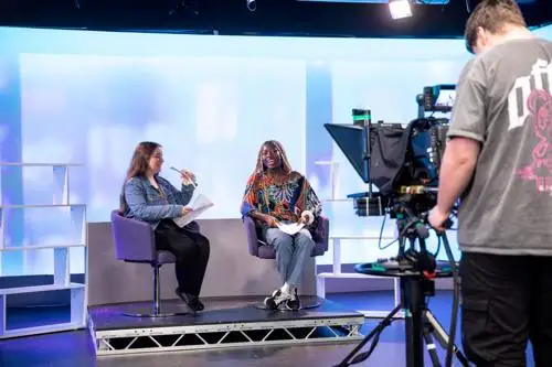 A mock studio with students creating a standard format TV show.