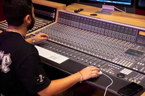 A student using a mixing desk in one of the live recording control rooms.