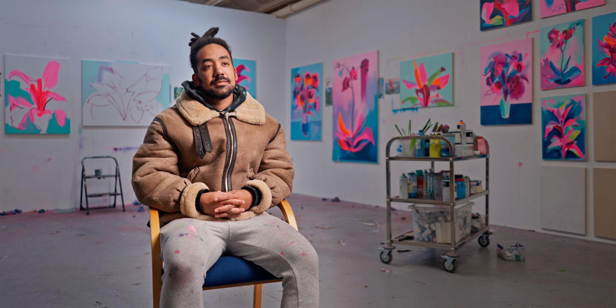 Video still of a man being interviewed in an art gallery