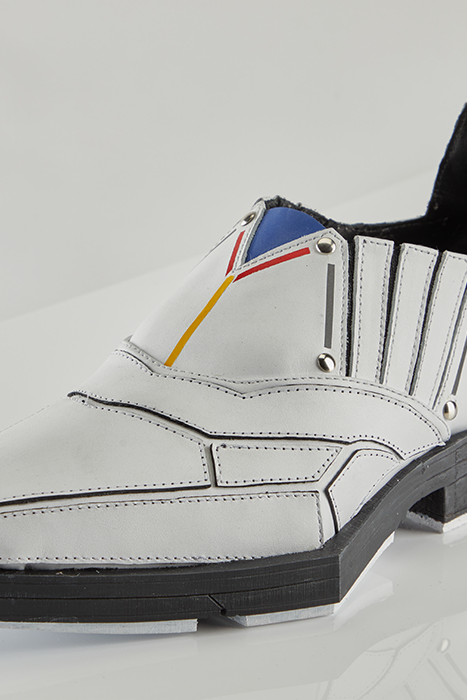 A white, masculine dress shoe with red, yellow, and blue highlights in a Gundam style