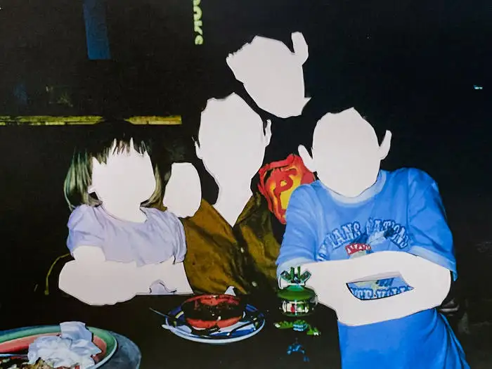 A portrait photo of four children sitting at a table; their faces have been erased - by Olivia Kerr