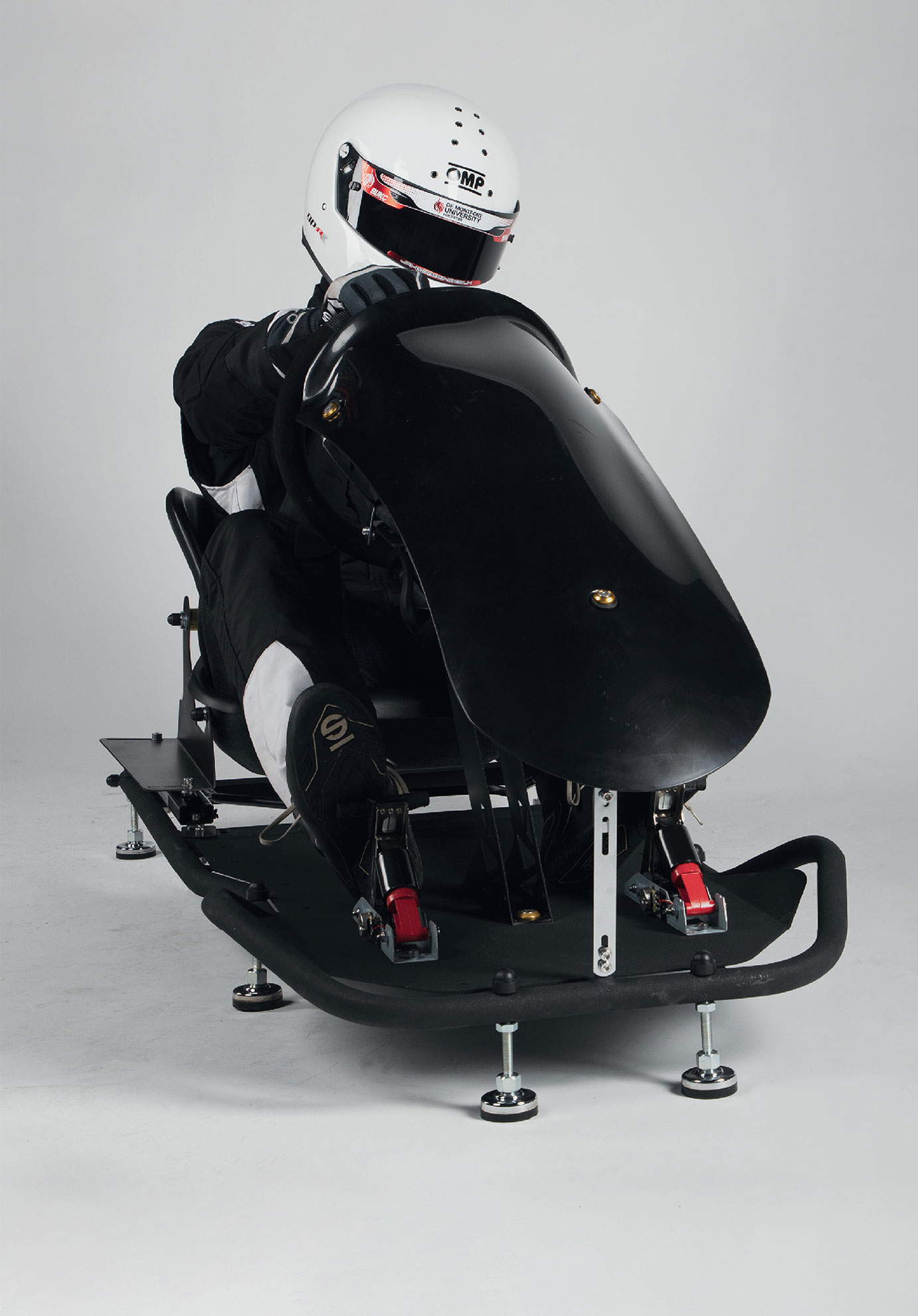 A student in a white helmet sitting in the Velocity Kart Simulator