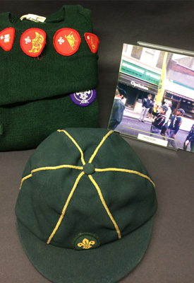 Stephen’s Cub Scout cap and jumper, with a photograph of him marching in a parade.