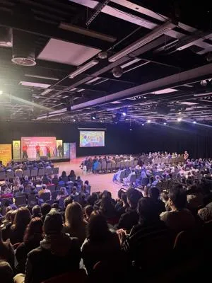 A large group of prospective students seated in a theatre at a DMU Open Day