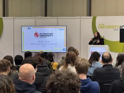 Evridiki standing at the podium delivering a talk to a full room of students at the WhatUni Exhibition in Birmingham.