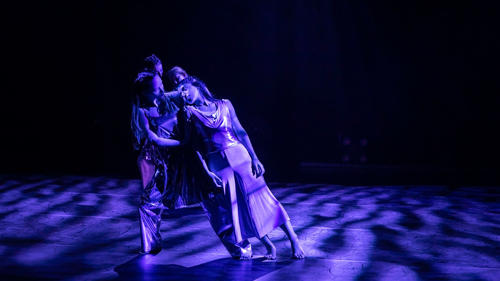 Dancers under mottled purple light